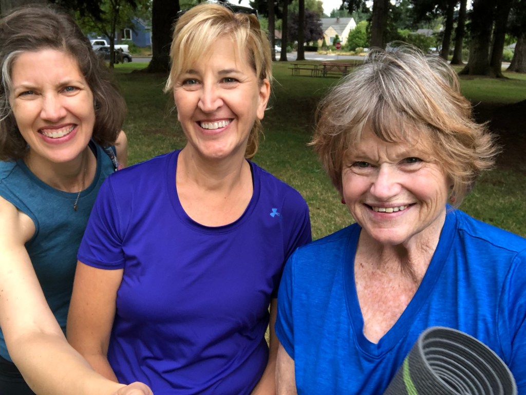 Friends posing after yoga in a tree-filled park