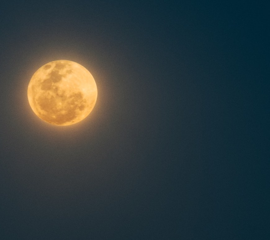 Full orange-colored moon glowing in a dark sky