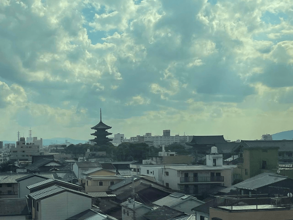 The city of Kyoto through the bullet train window, a pagoda rises among office and residential buildings
